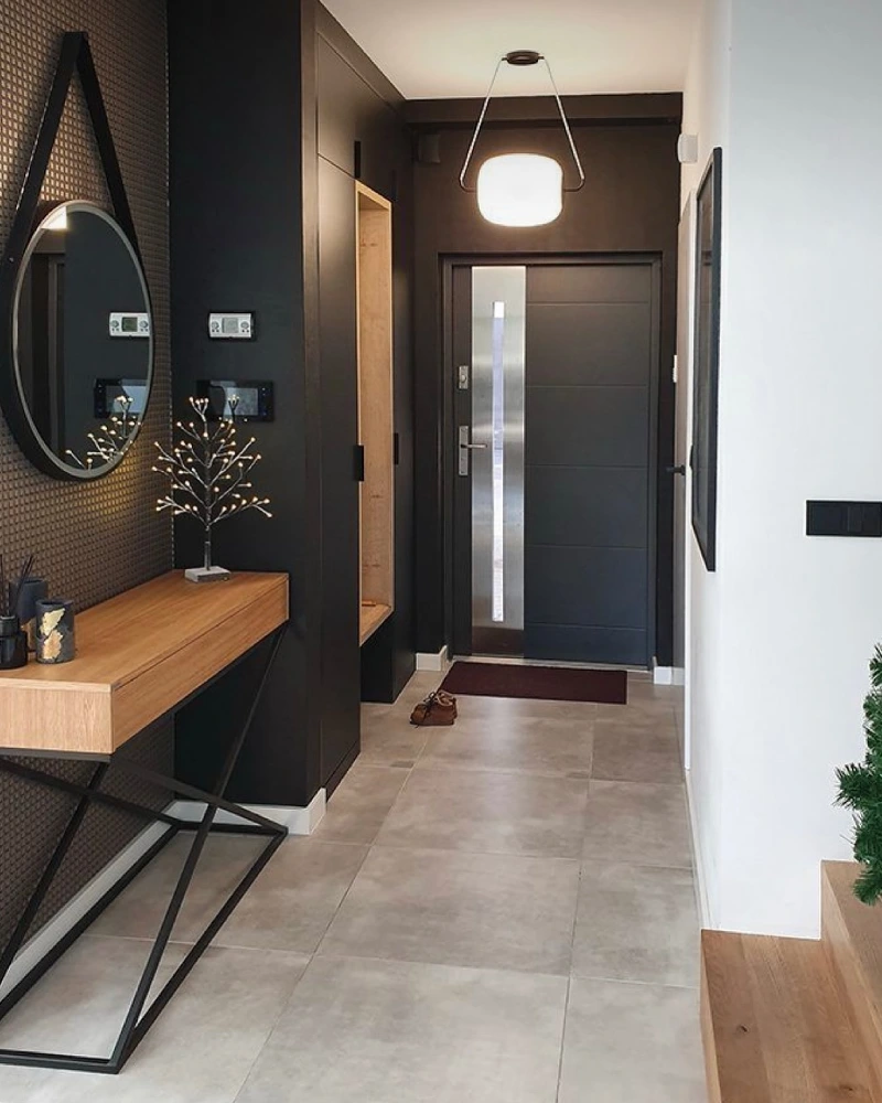 Matte Black Entryway Storage Wall with Light Wood Console and Round Hanging Mirror