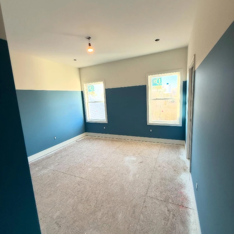 Mid-Tone Blue and Cream Split-Color Painted Bedroom with White Trimmed Windows