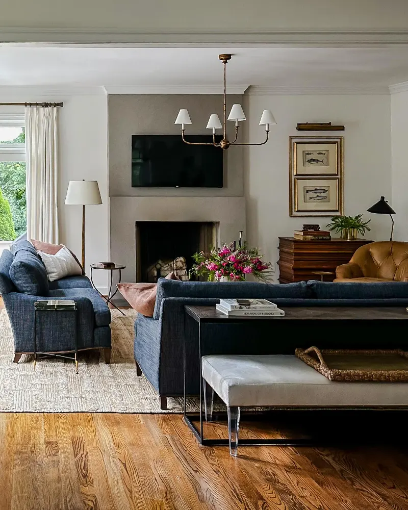 Minimalist Stone Fireplace paired with Navy Sofas and Brass Lighting
