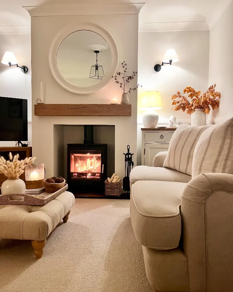 Modern Round Mirror with Beige Rolled-Arm Sofa and Glowing Wood-Burning Stove