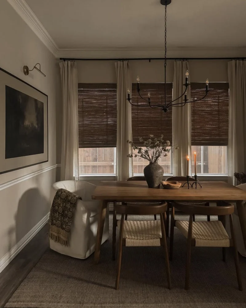 Moody Warm Dining Room with Woven Blinds, Candlelight, and Woven-Seat Chairs