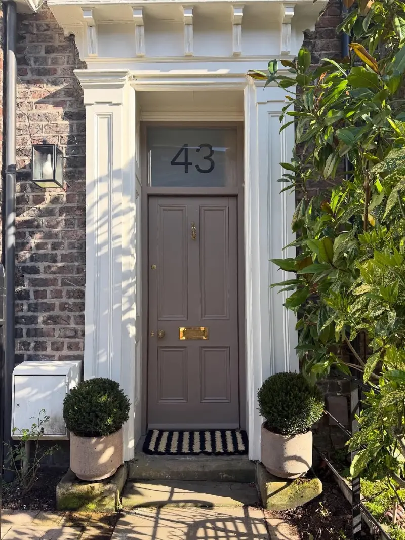 Mushroom Taupe Front Door with Brass Details and Boxwood Planters