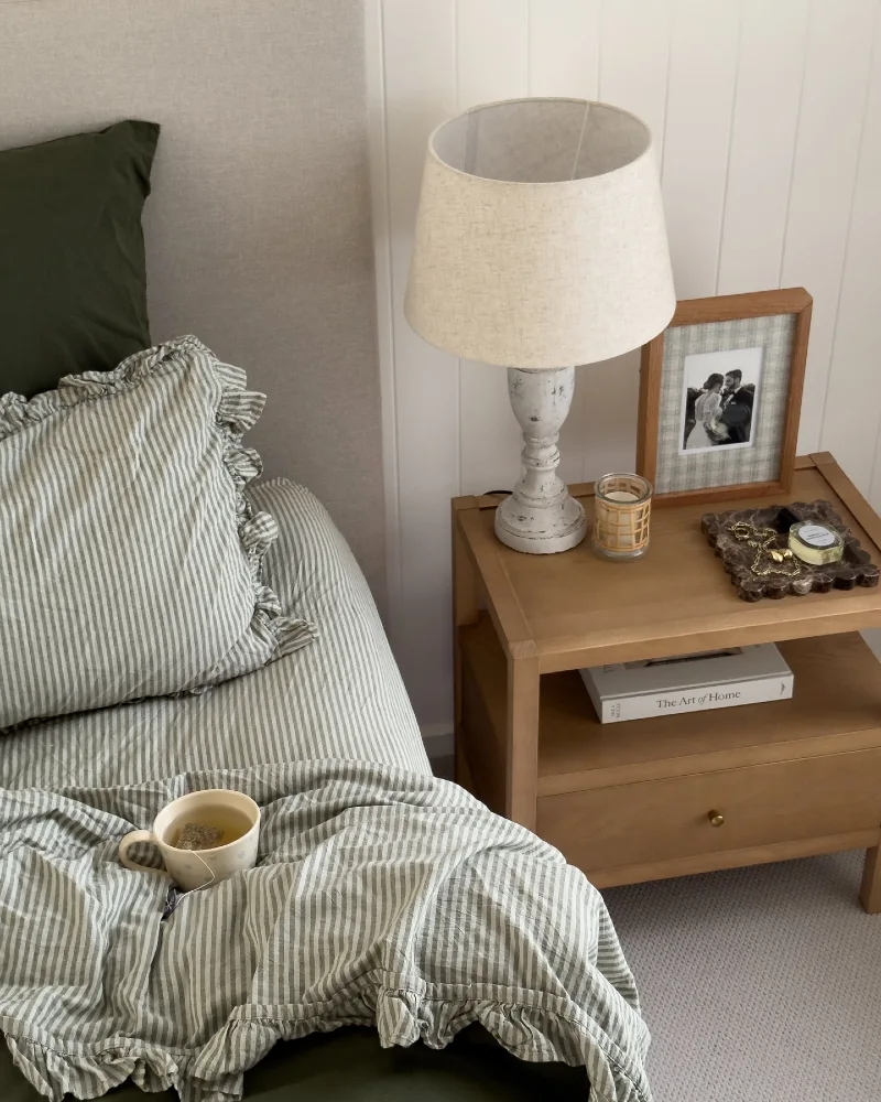 Oak Open-Shelf Nightstand with Distressed Baluster Lamp and Ruffled Ticking Stripe Linens