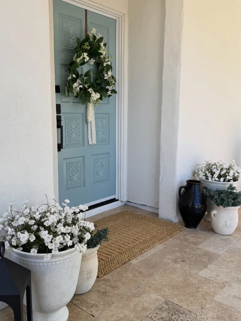 Powder Blue Double Doors with White Florals and Sculptural Urns