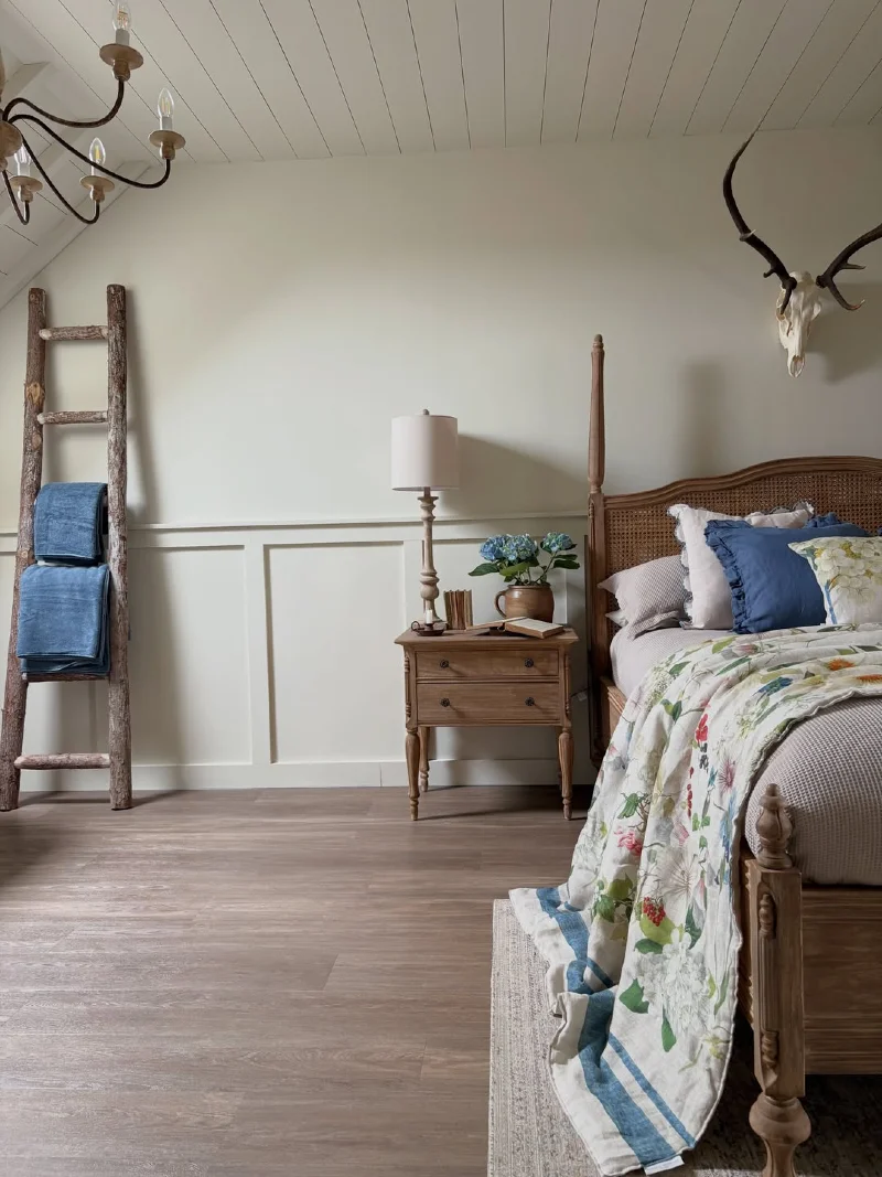 Rattan Canopy Bed with Floral Throw and Rustic Wooden Ladder