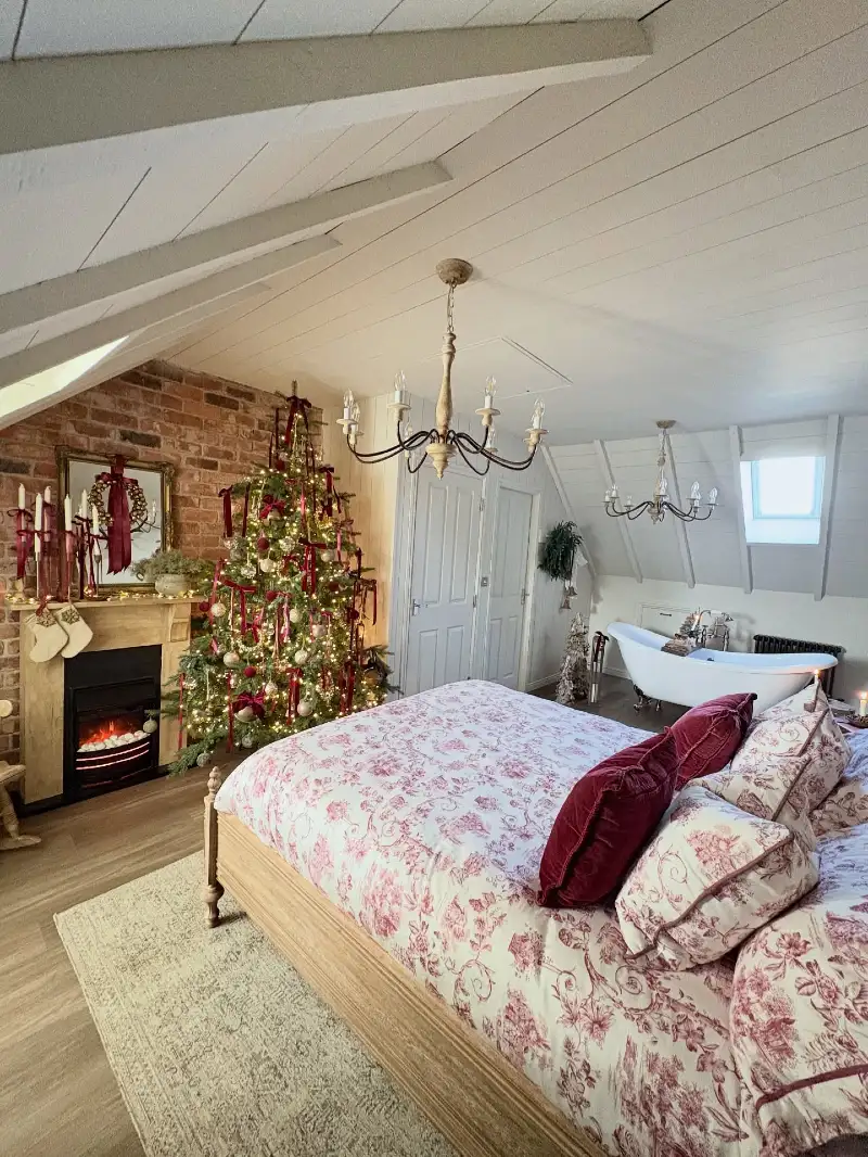 Red Toile Bedding and Velvet Pillows with Ribbon-Adorned Tree and Exposed Brick