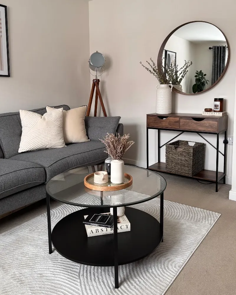 Round Glass Coffee Table with Textured Cream Rug and Wooden Accents