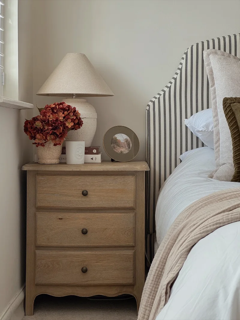 Scalloped Oak Nightstand with Conical Stone Lamp and Ticking Stripe Headboard