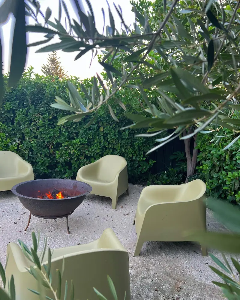 Sculptural Outdoor Chairs Around a Rustic Steel Fire Bowl