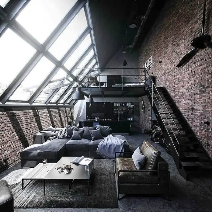 Slanted Skylight Loft With Black Mezzanine And Gray Sectional