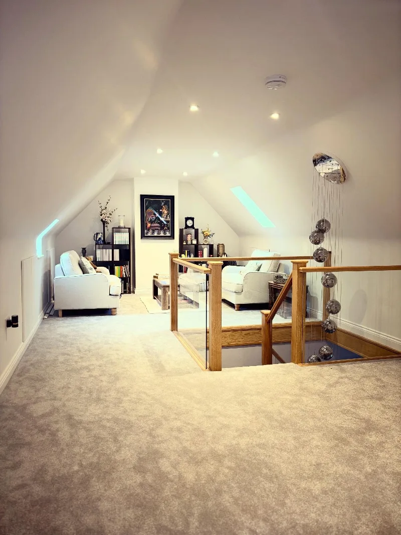 Sloped Attic Lounge with Wall-to-Wall Carpet and Hanging Sphere Chandelier