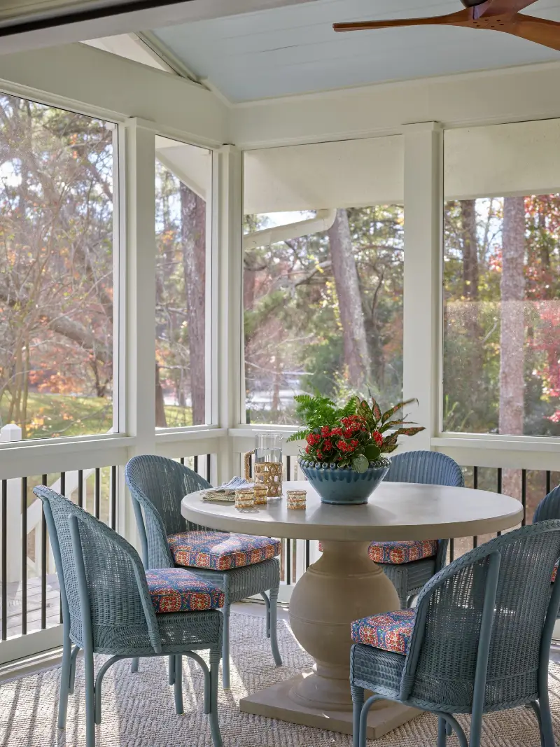 Stone Pedestal Dining Table with Blue Wicker Chairs and Patterned Cushions