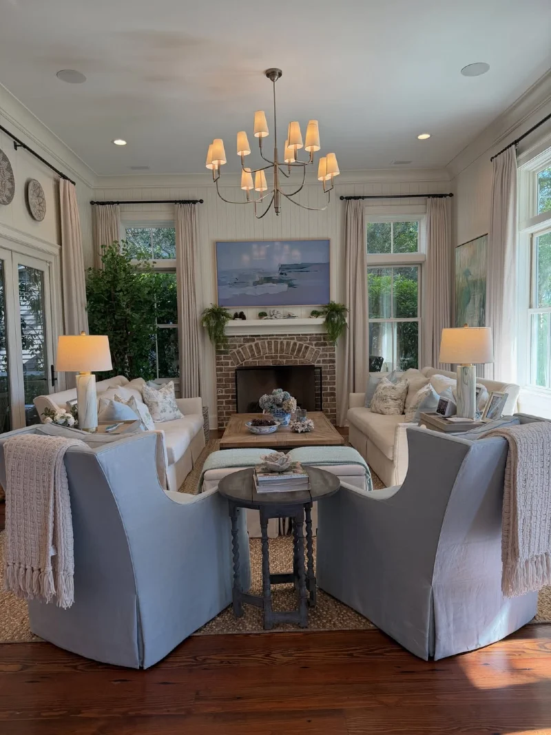 Symmetric Cream Sofas with Faint Blue Wingback Chairs and Brick Hearth