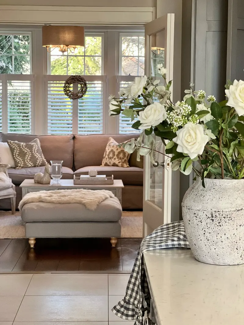 Taupe Sunroom Living Area with White Rose Floral Anchor and Sheepskin Footstool