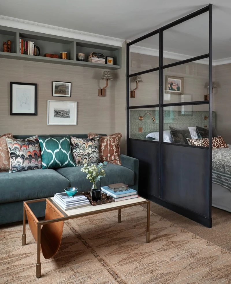 Teal Sofa Against Picture Wall with Black Glass Bedroom Divider