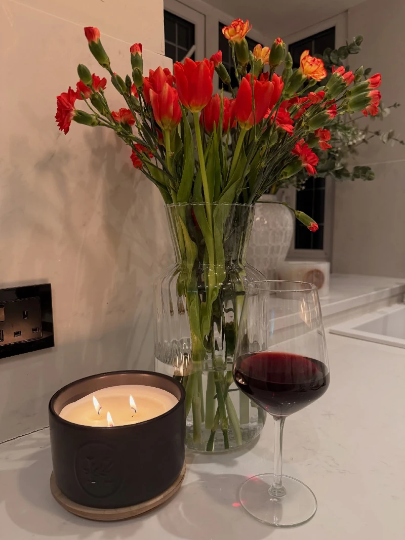 Three-Wick Matte Ceramic Candle with Tall Glass Tulip Vase on a Marble Countertop
