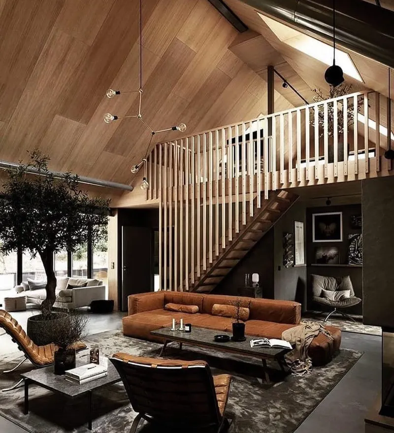 Vertical wood slat stair guard with vaulted timber ceiling and cognac leather sectional