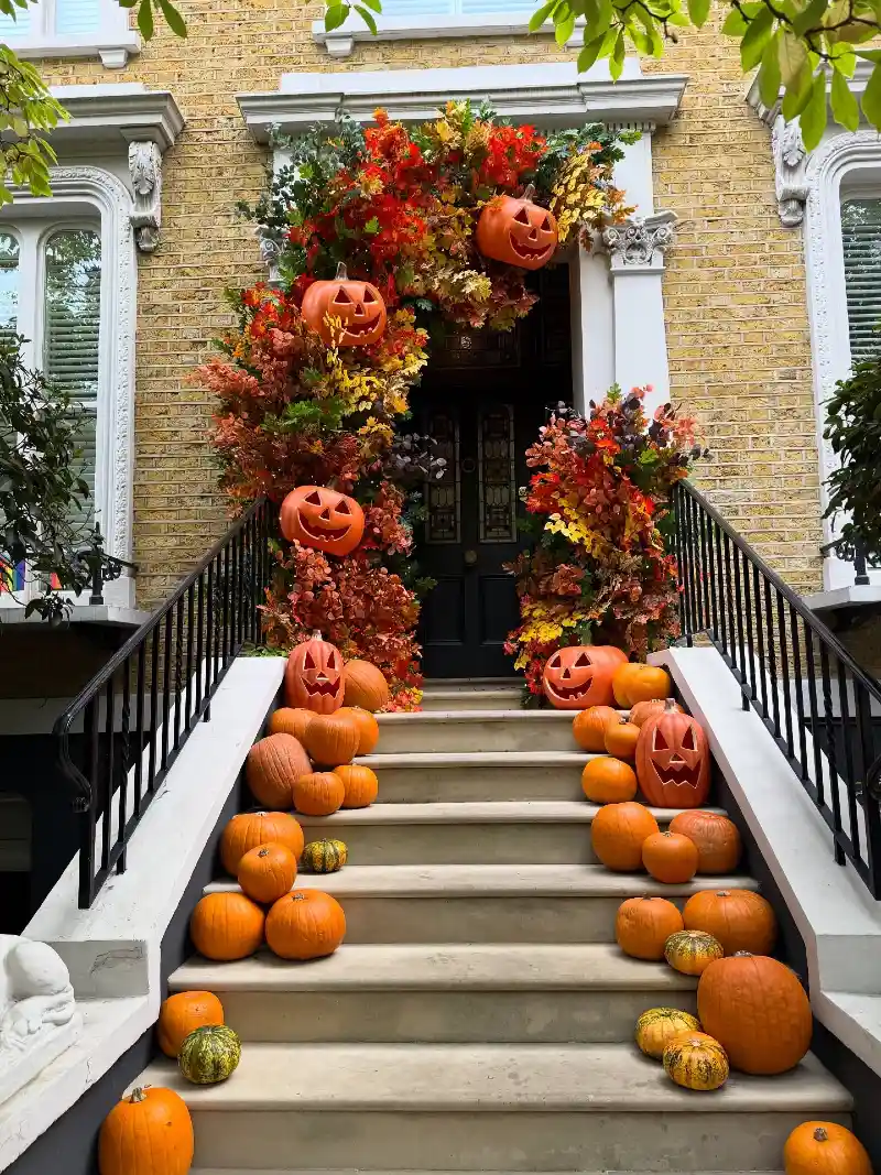 Vibrant Autumn Foliage Archway with Carved Jack-o'-Lanterns on Stone Steps