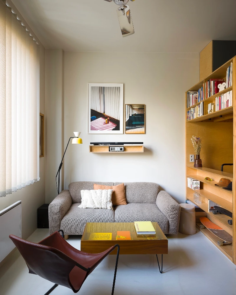 Wall Length Bookshelves with a Bouclé Sofa and Leather Sling Chair
