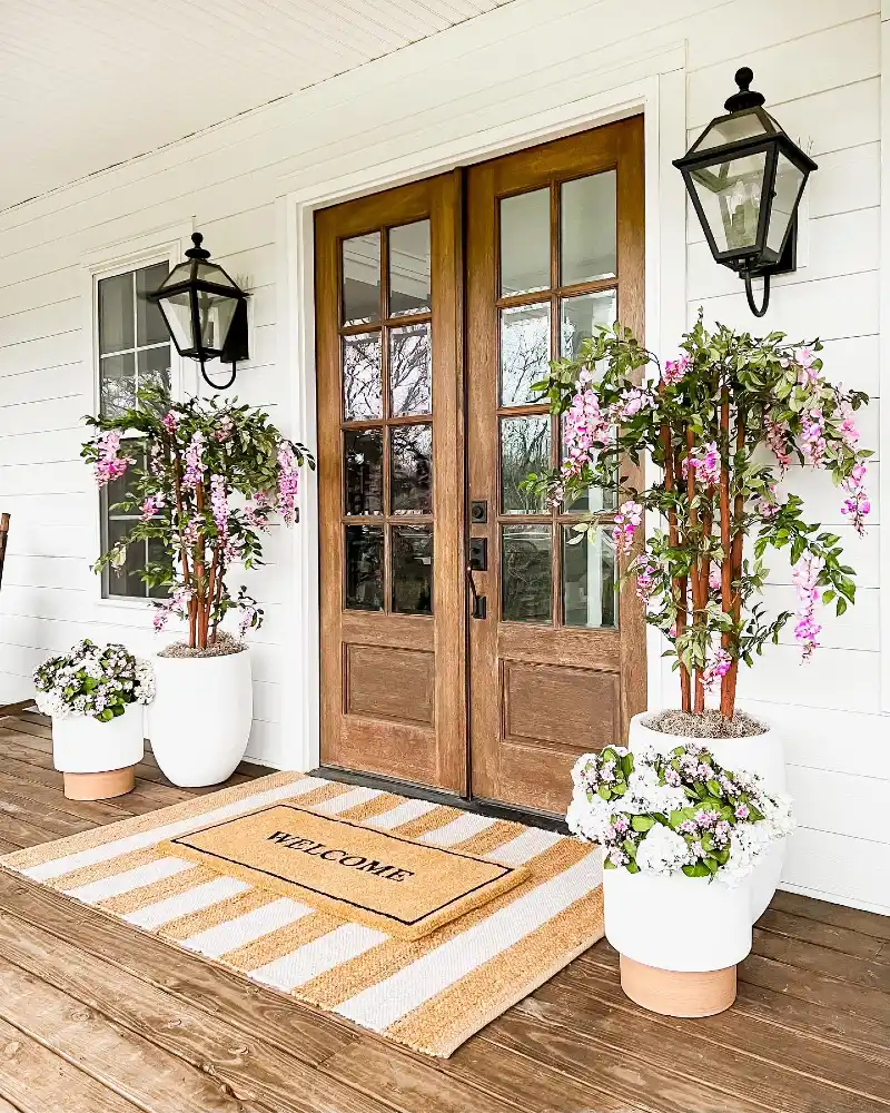 Warm Wood Double Doors with Cascading Pink Florals and Striped Rugs