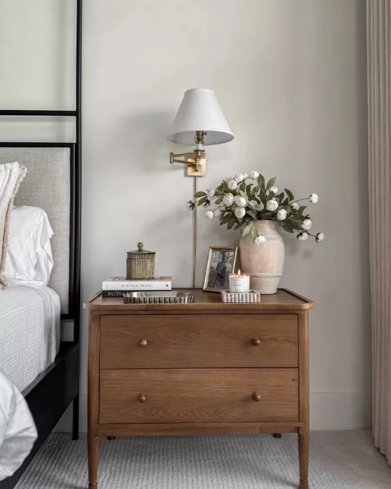 Warm Wood Mid-Century Nightstand with Brass Swing-Arm Sconce and White Florals