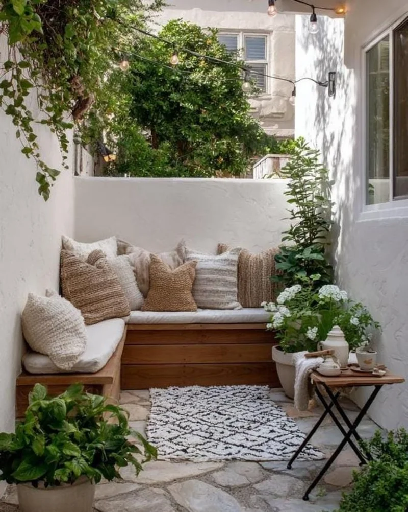 White Stucco Courtyard with Built-In Wooden Bench and Textured Neutral Cushions