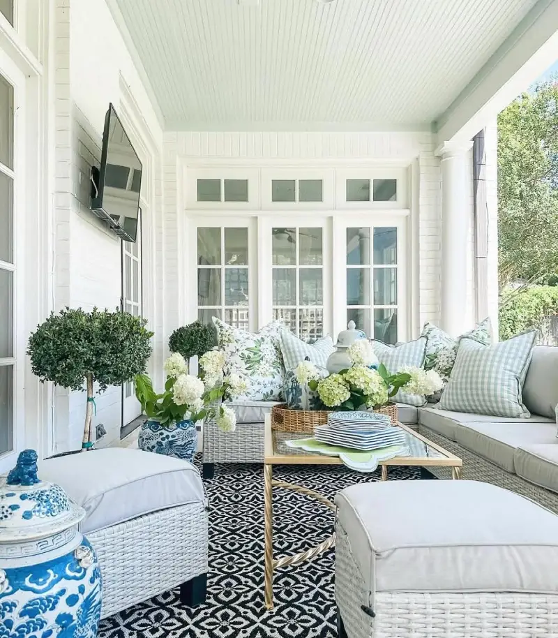 White Wicker Sectional with Black Geometric Rug and Blue and White Ginger Jars