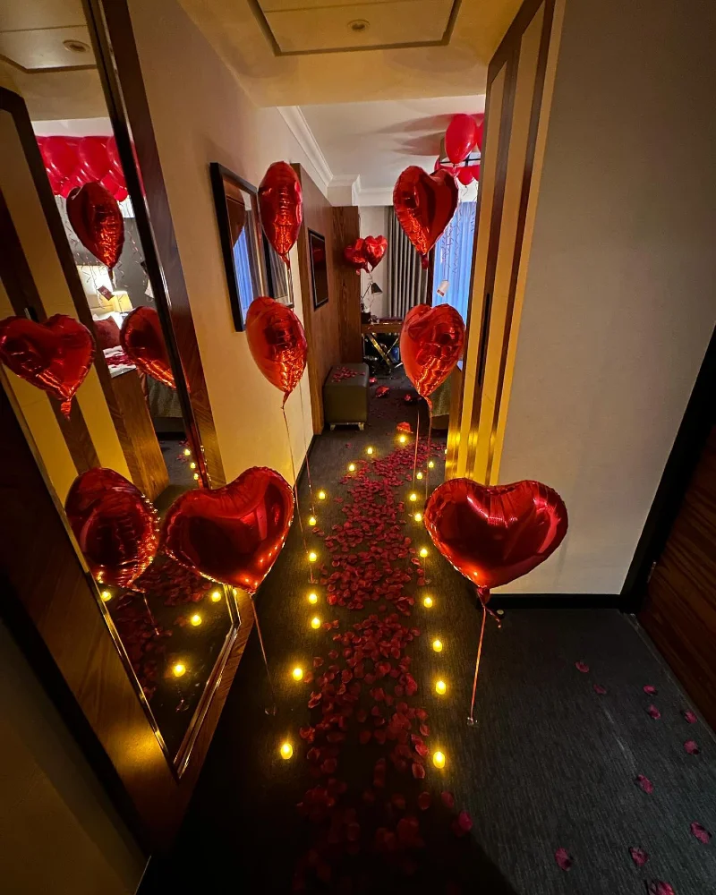 Wood-Paneled Hallway Mirror with Floating Red Foil Hearts and Luminous Candle Trail