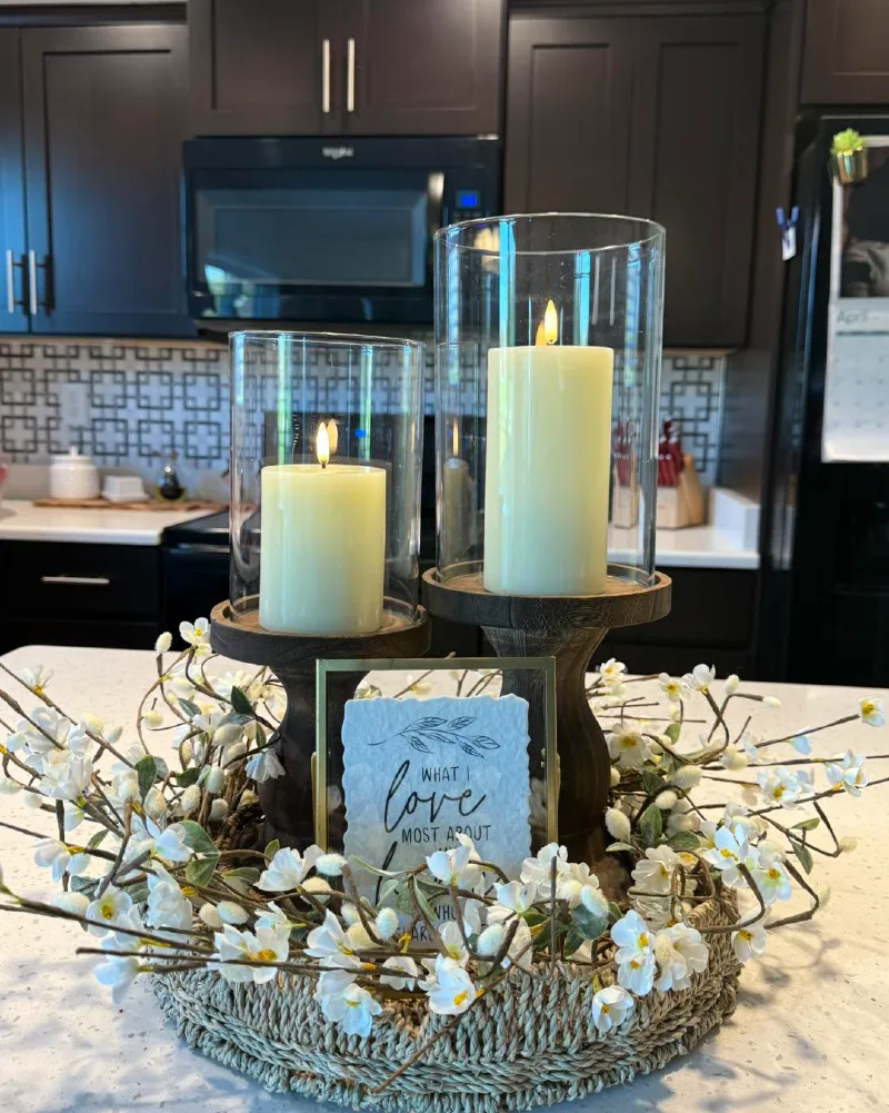 Wooden Pedestal Hurricanes with Faux White Blossom Wreath on a Kitchen Island