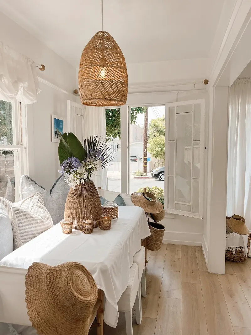 Woven Rattan Pendant Light over Breakfast Nook with Straw Hats and Linen Cushions