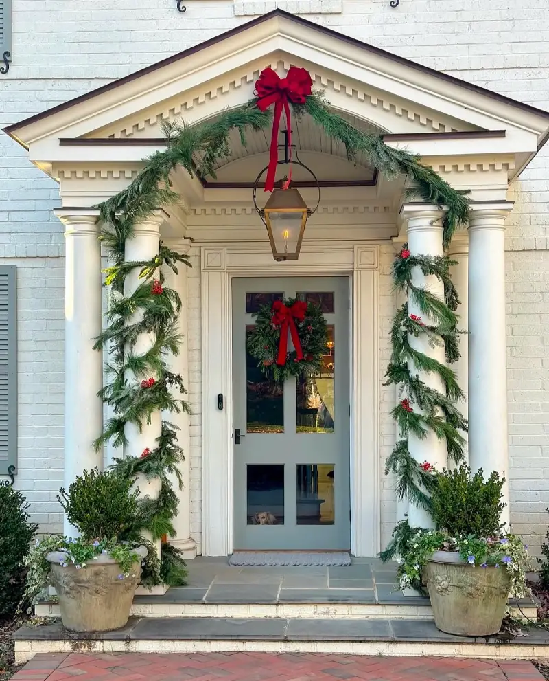 Wrapped Column Garlands with Red Velvet Bows and Stone Planters