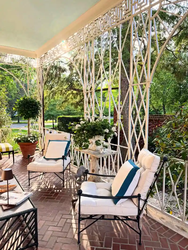 Wrought Iron Armchairs with Geometric Trellis Screen and Herringbone Brick Floor