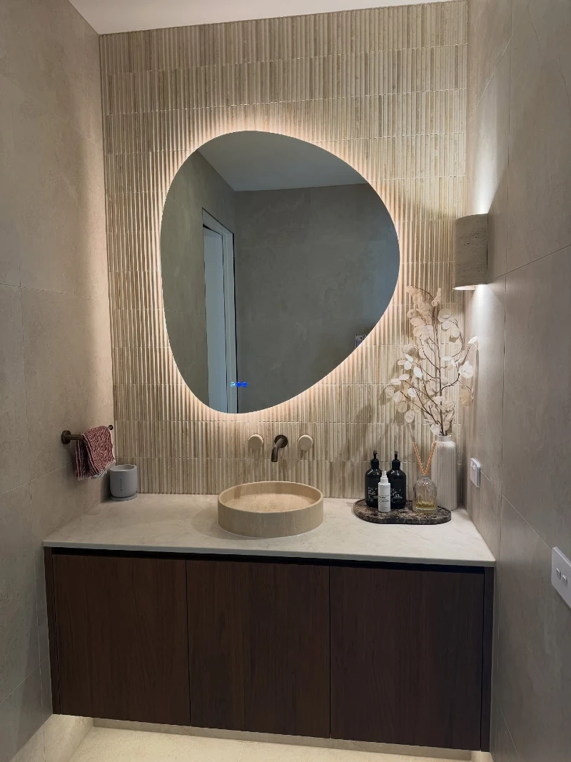 Backlit Organic Mirror against Vertical Stone Mosaic