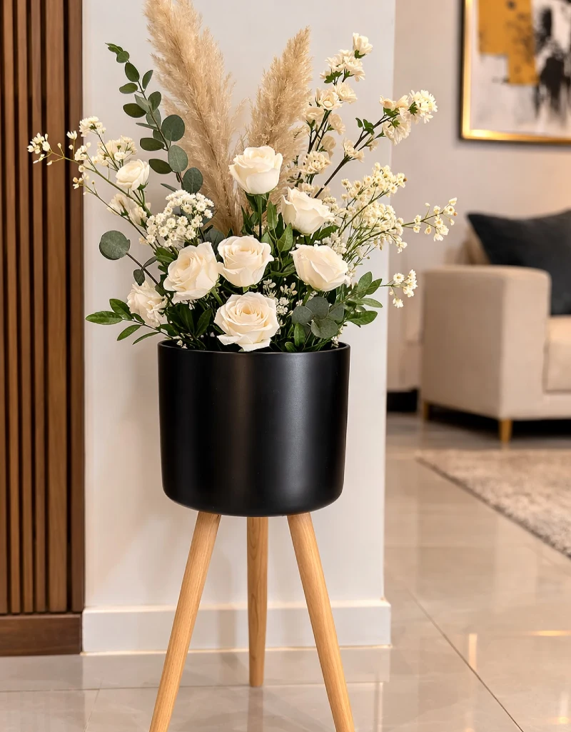 Black Cylindrical Planter on Wooden Tripod Stand with Cream Roses and Pampas Grass