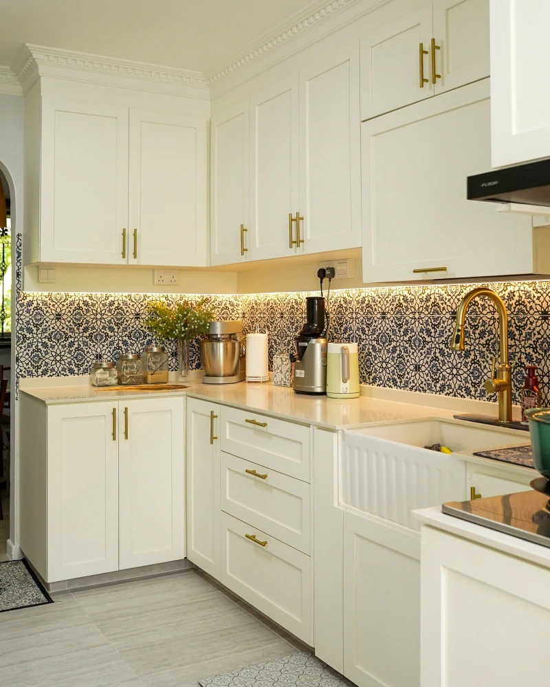 Blue and White Floral Pattern Tile with Cream Cabinets and Brass Fixtures
