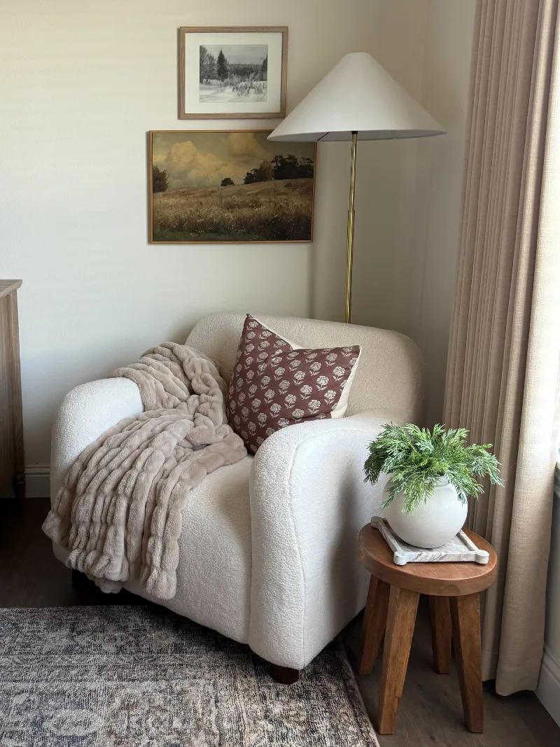 Bouclรฉ Reading Chair with Brass Floor Lamp and Wood Side Stool
