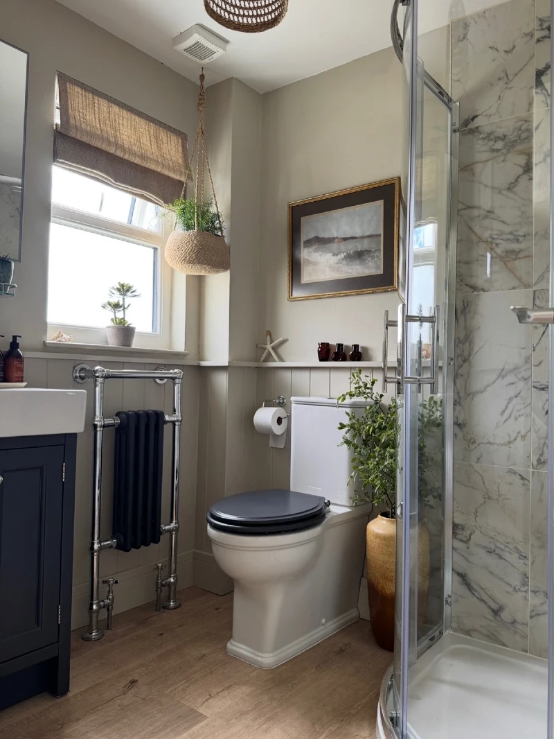 Cottage Bathroom with Curved Glass Shower Stall and Traditional Column Radiator
