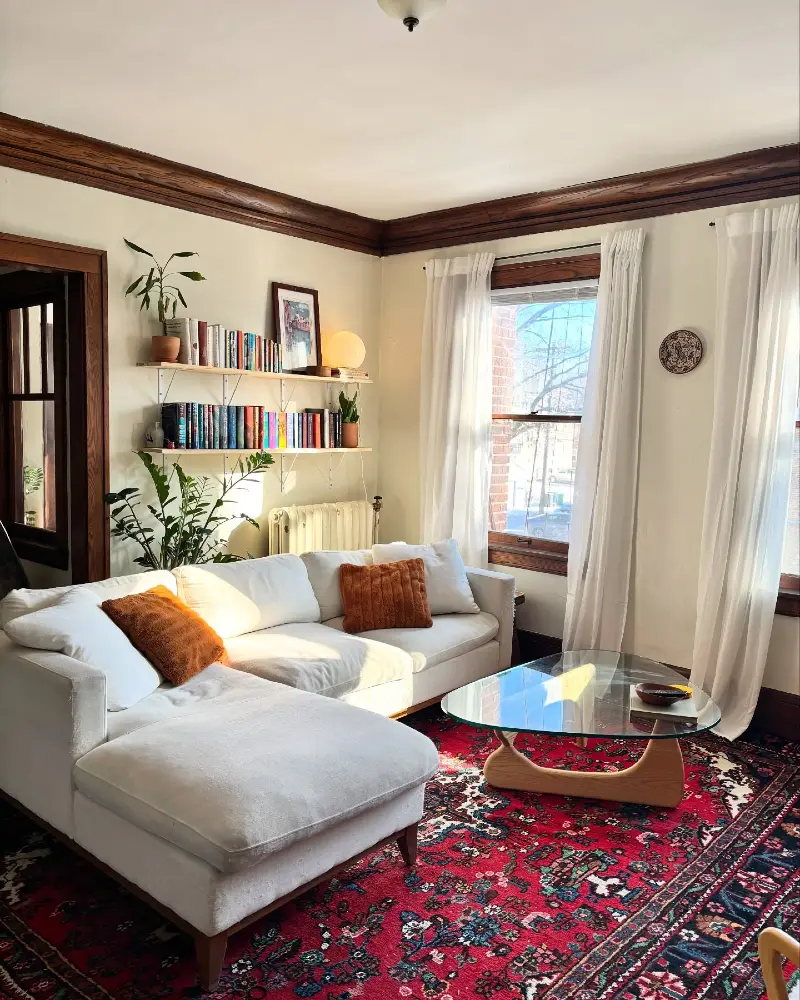 Crisp White Sectional with Red Persian Rug and Triangular Glass Coffee Table