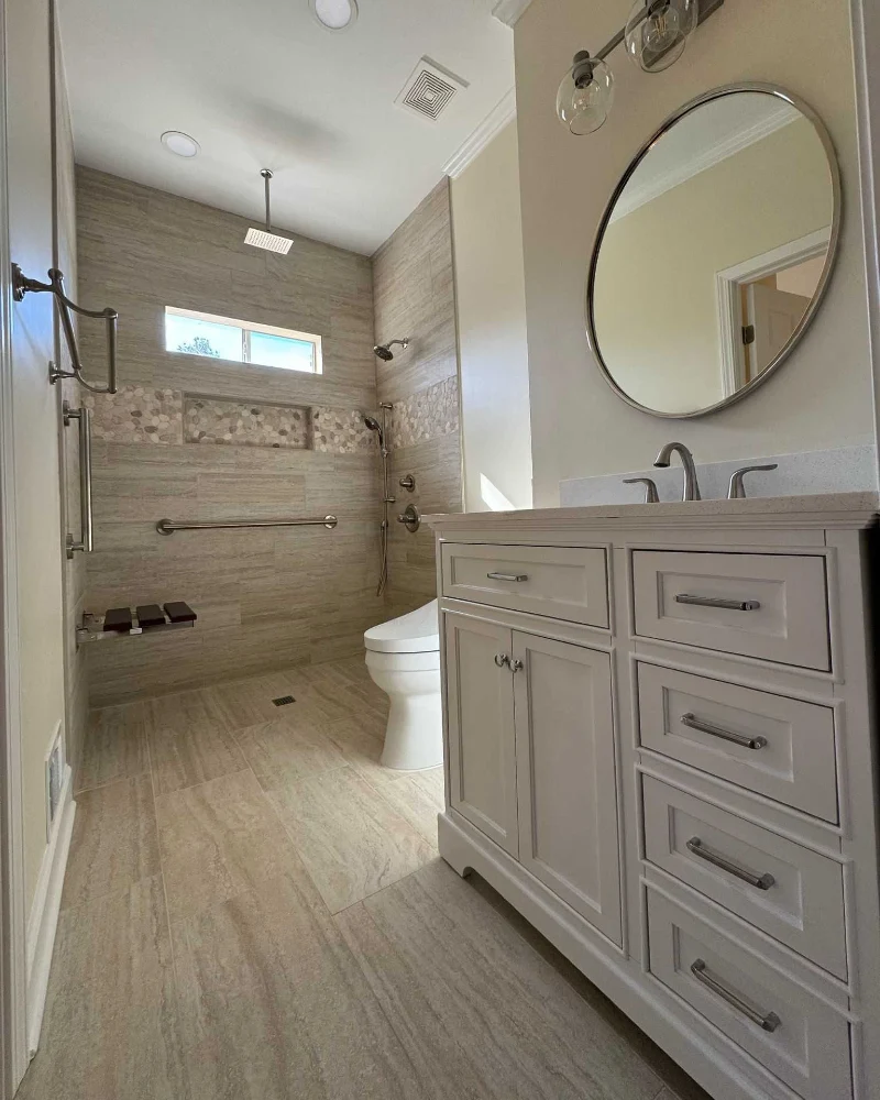 Curbless Wet Room with Pebble Accent Tile and Floating Shower Seat