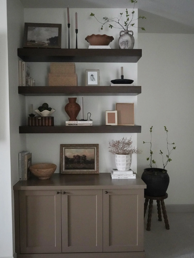 Dark Wood Floating Shelves with Vintage Art, Pottery, and Candlesticks