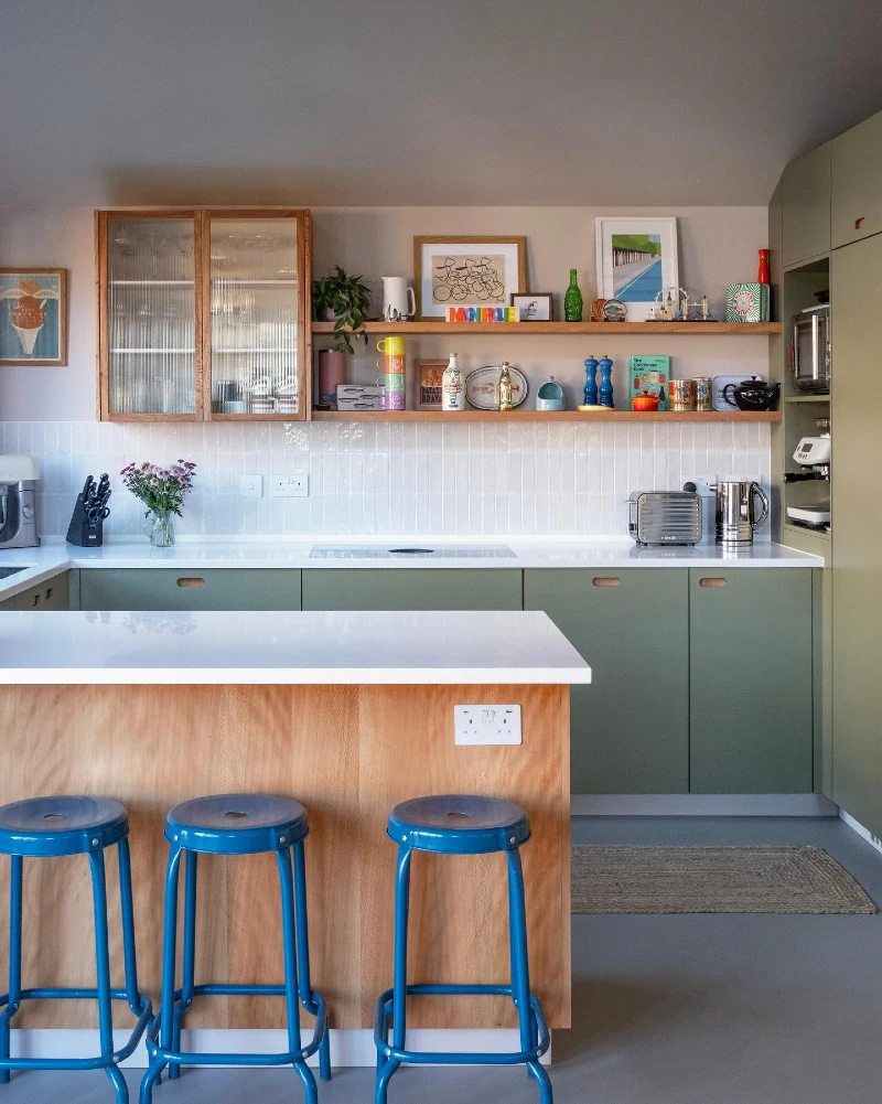Double Oak Shelves with Colorful Ceramics, Framed Art, and Blue Bar Stools