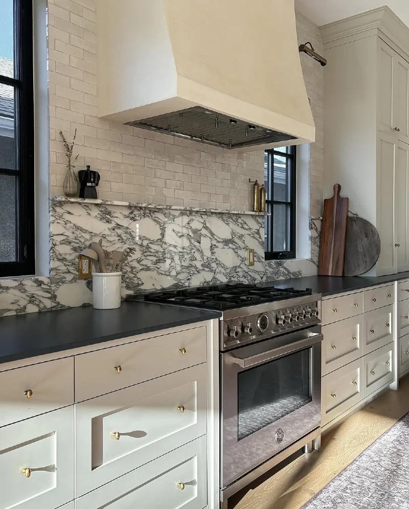 Dramatic Marble Slab Backsplash with White Brick Tile Above