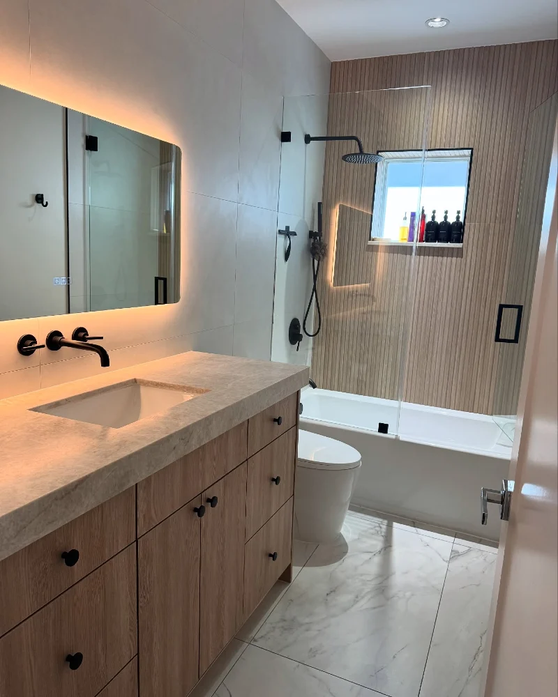 Fluted Wood Accent Wall with Backlit Vanity Mirror and Black Matte Fixtures