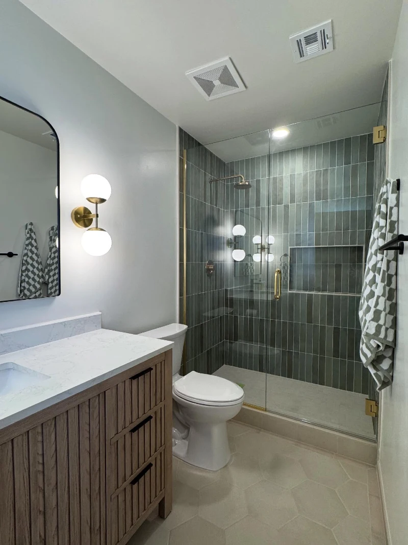Fluted Wood Vanity with Dark Olive Finger Tile Shower and Globular Sconce