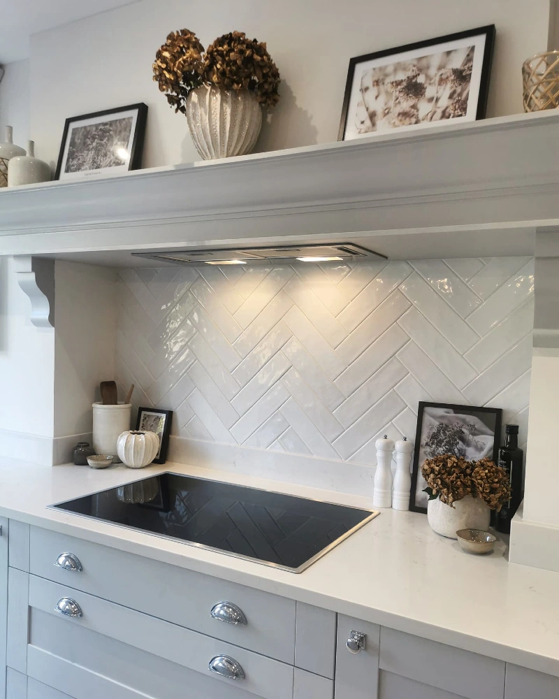 Glossy White Herringbone Tile Framed by a Deep Mantel Shelf