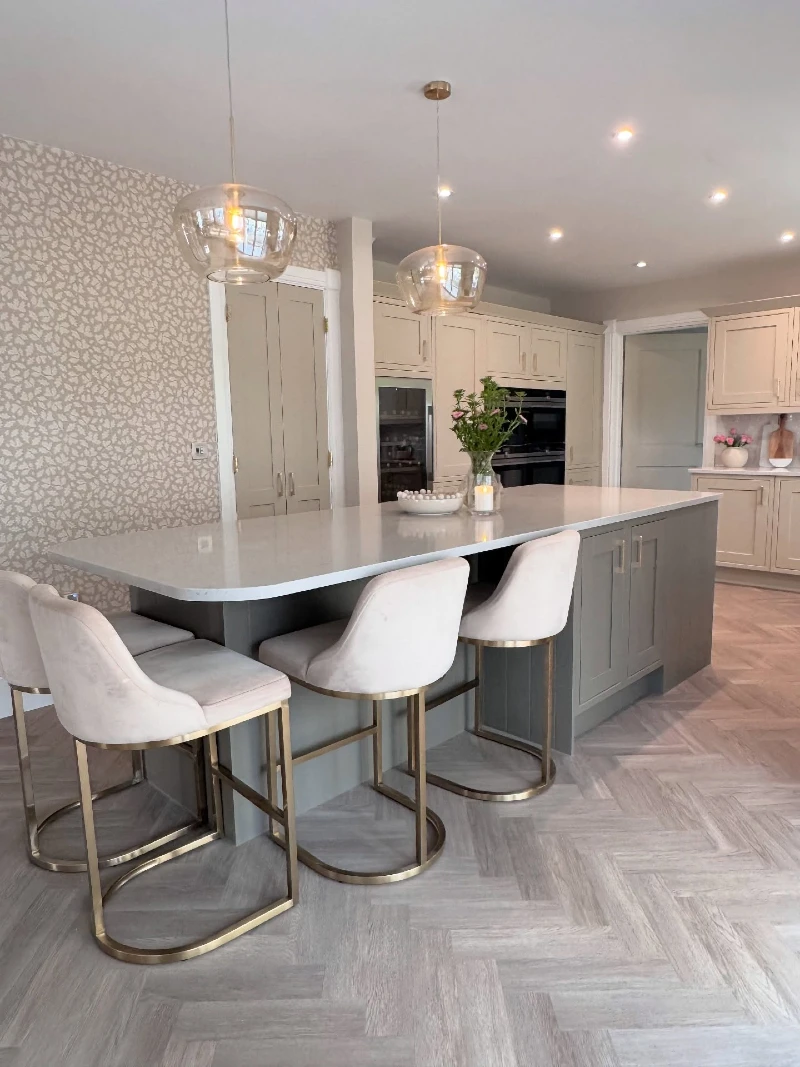 Gray Curved Island with Brass Framed Stools and Wraparound Seating