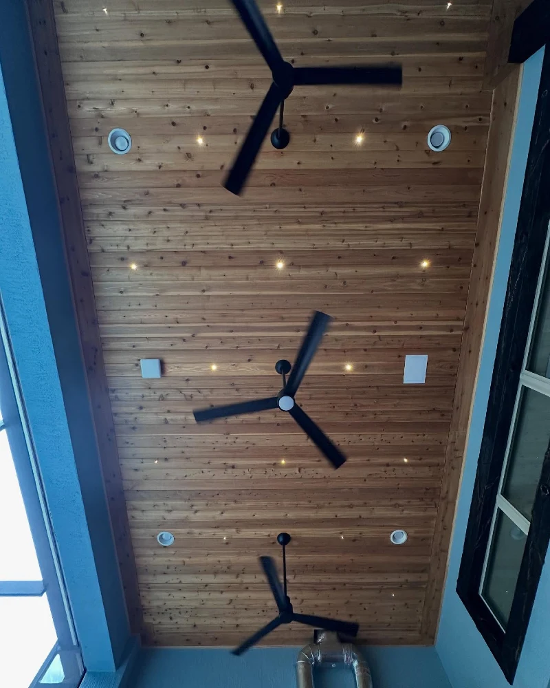 Knotty Wood Ceiling with Starry LED Pinpoints and Triple Black Fans