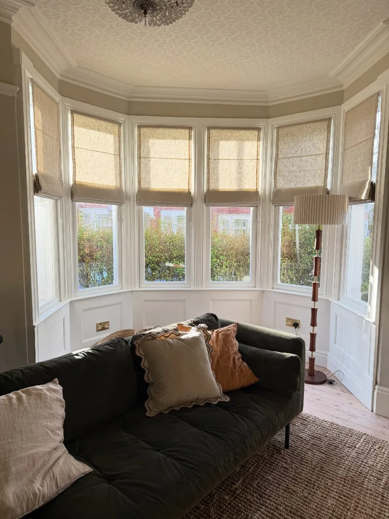Neutral Roman Shades Across a Sunlit Victorian Bay Window