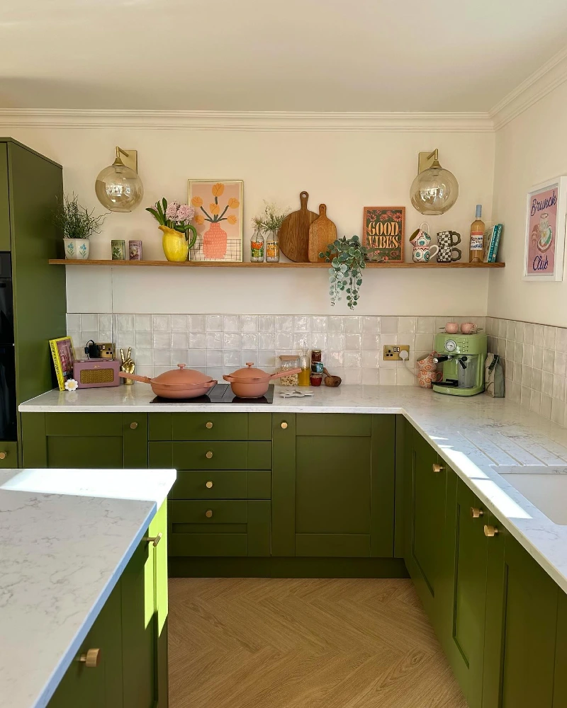 Olive Shaker Cabinets with a Single Wood Shelf, Framed Art, and Warm Brass Accents