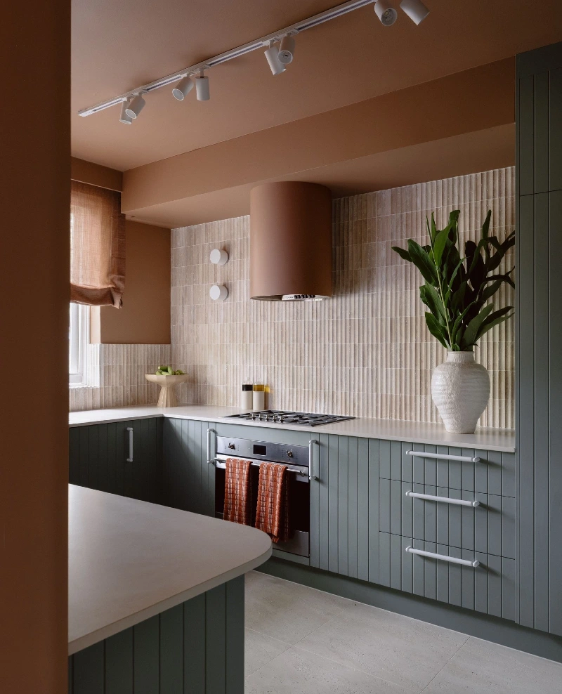 Ribbed Cream Tile with Terracotta Hood and Deep Green Cabinetry